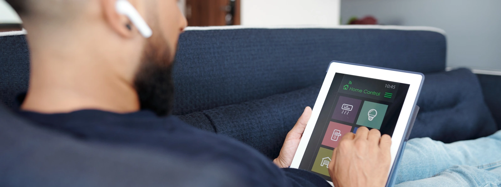 Person using tablet for home automation control.