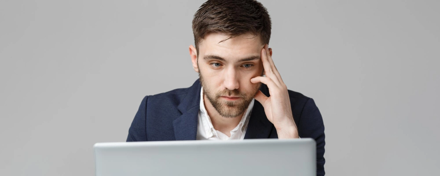 Man thinking while working on laptop