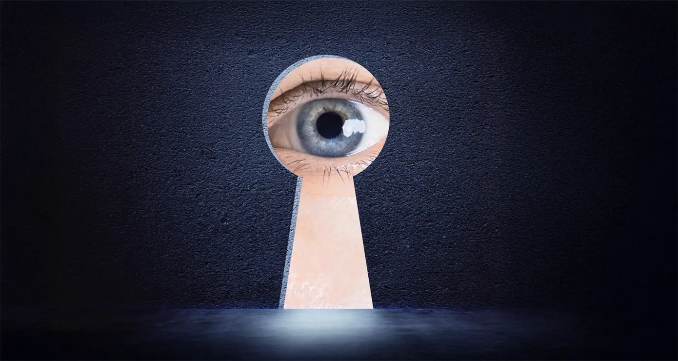 Close-up of an eye through a keyhole.
