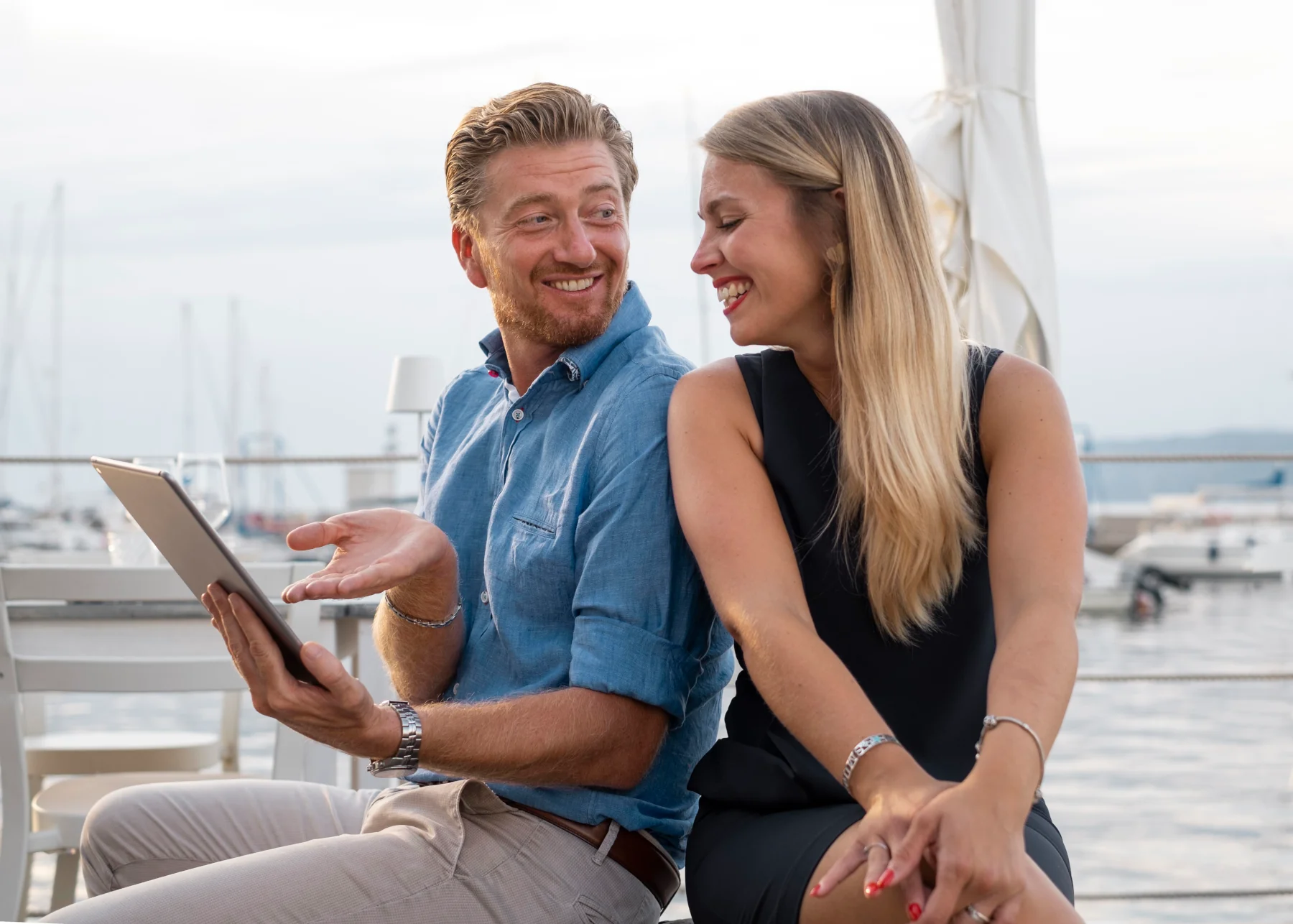 Smiling couple enjoying a waterfront conversation.